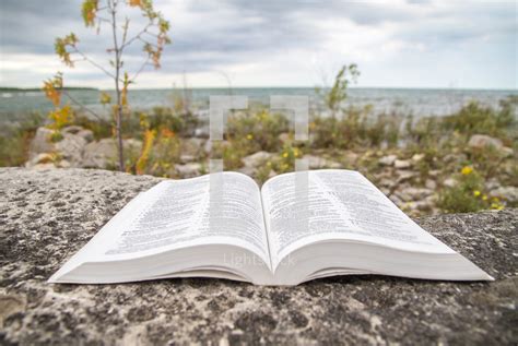 Open Bible On A Rock With A Coastline In The — Photo — Lightstock
