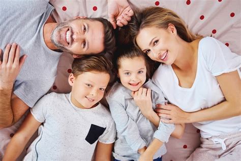 Retrato De Familia Feliz Acostado En La Cama Foto Gratis