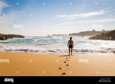 Woman Walking On The Sand Of A Beautiful Beach Stock Photo Alamy