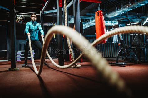 Fit Man Working Out With Battle Ropes At Fitness Gym Stock Photo