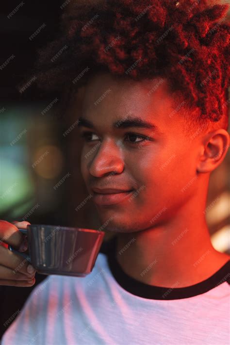Premium Photo Smiling African Young Man Drinking Coffee At The Cafe