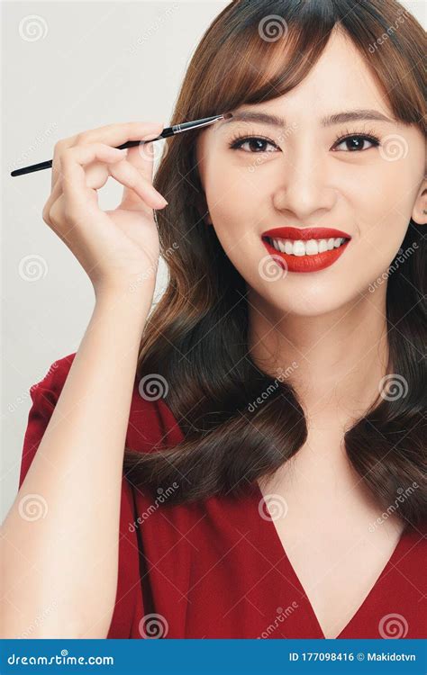 Asian Young Beautiful Woman Applying Cosmetic Powder Brush On Eyebrow