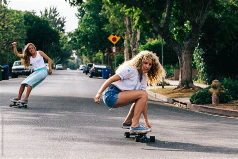 Two California Girls Skateboarding Sunny Streets Of Venice Beach By