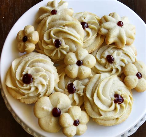 Cream together butter and sugar. Create festive cookie designs by filling a piping bag with cookie batter and piping various ...