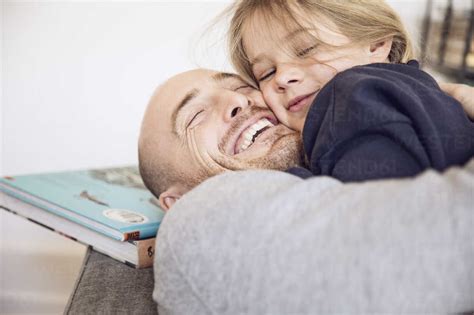 Happy Father Embracing Daughter At Home Stock Photo