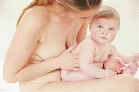 Naked Mother Bonding With Naked Baby On Lap Stock Photo Dissolve
