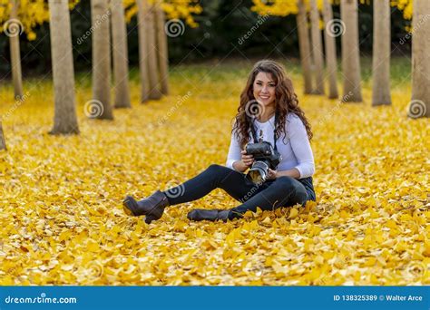 Brunette Model Enjoying A Fall Day In Fall Foliage Holding A