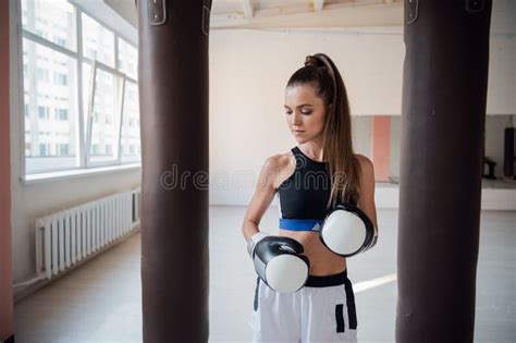 Female Athlete Boxing The Punching Bag In Urban Industrial Gym Stock