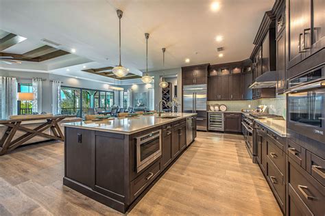A Large Kitchen With Wooden Floors And Stainless Steel Appliances