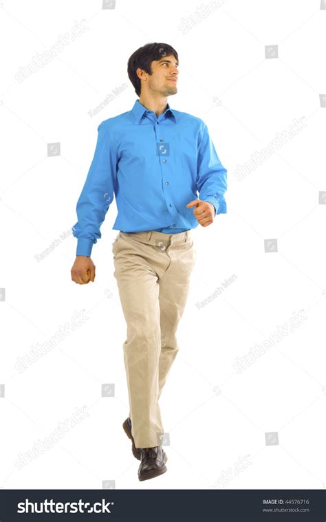 A Young Businessman Is Walking He Is Smiling And Looking Away From The