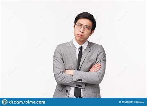 Waist Up Portrait Of Puzzled Serious Looking Asian Guy In Grey Suit