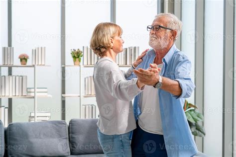 Portrait Of Happy Senior Couple Dancing In Living Room Elderly Woman