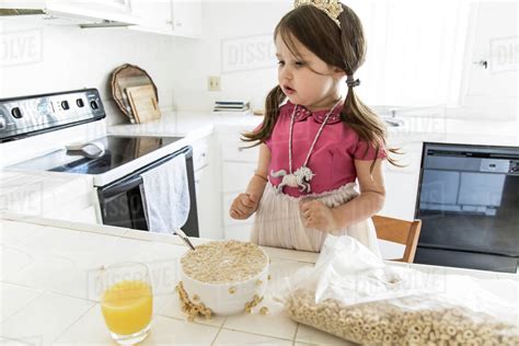 Caucasian Girl Eating Cereal In Kitchen Stock Photo Dissolve