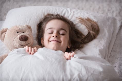 Wir begrüßen sie als interessierten leser zum großen vergleich. Kleines süßes mädchen im bett mit spielzeug | Kostenlose Foto