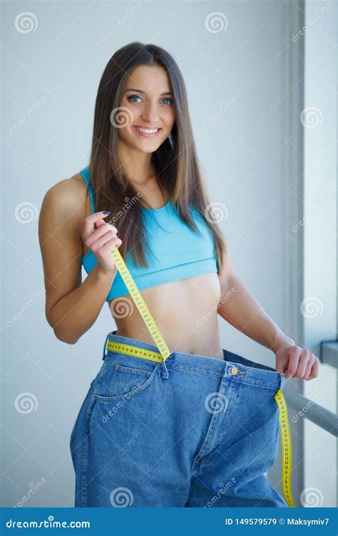 Diet Woman Shows Her Weight Loss And Wearing Her Old Jeans Stock Image Image Of Concept