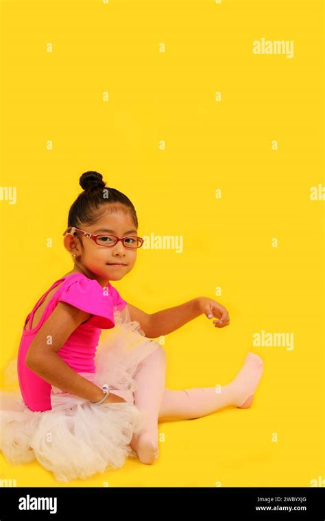 4 Year Old Brunette Latina Girl With Eyeglasses Dressed In Pink Leotard