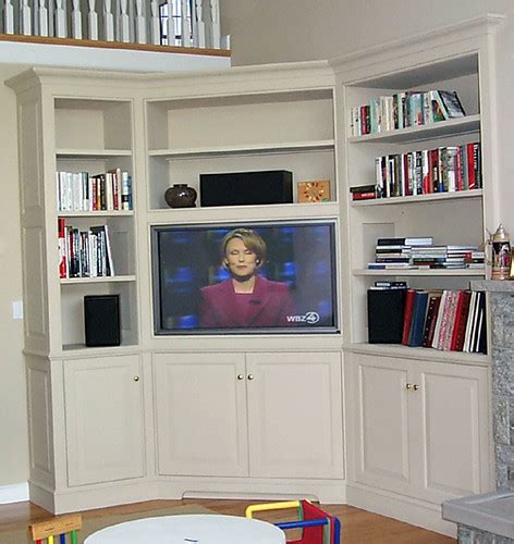 Blond wooden prism tv cabinet with legs in a transitional living room keeps a minimalistic design with a sleek appeal. Built-in corner entertainment center | Traditional cabinet ...