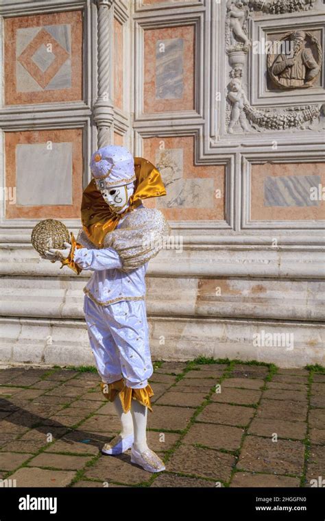 un adivino y arlequín o arlecchino en fancy dress trajes y la máscara en el carnaval de venecia