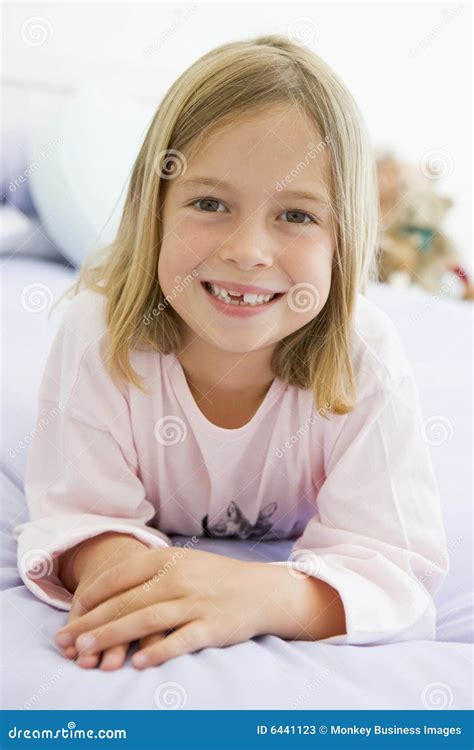 Rapariga Que Encontra Se Em Sua Cama Em Seus Pijamas Imagem De Stock Imagem De Vertical