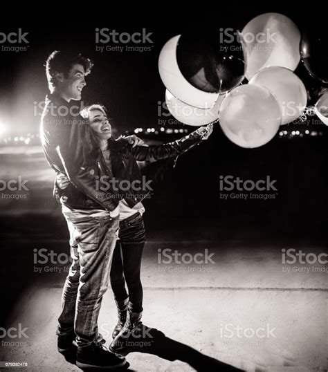 Romantic Teenage Couple Celebrating With Balloons At Night Stock Photo