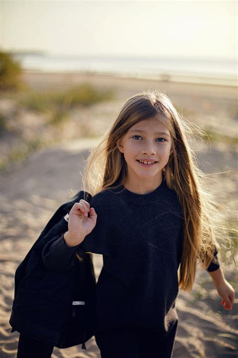 Portrait Of A Girl With Long Hair Sitting On A Sandy Beach Photograph