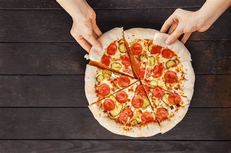Premium Photo Top View Of Two Hands Taking Slice Of Pizza Pepperoni