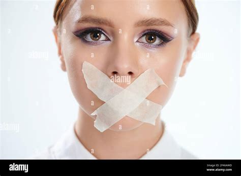 Headshot Of Woman With Taped Mouth Close Up Isolated On White Studio