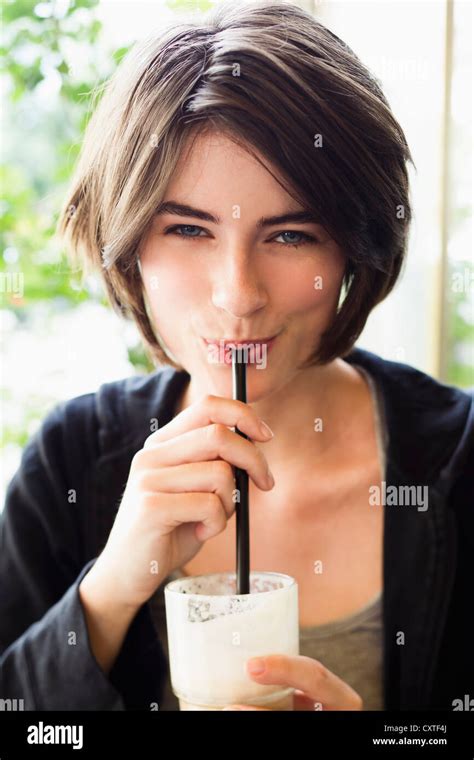 Smiling Woman Drinking Through Straw Stock Photo Alamy