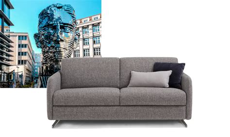 Letto su misura con piedini alti in legno e testata decorata da un soffice cuscino fermato con cinghie in pelle nabuk. Praga | divano letto moderno con piedini alti | TINO MARIANI
