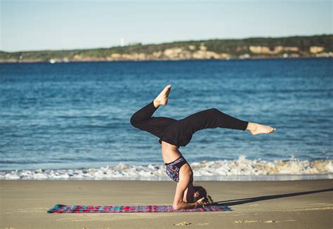 fit woman doing headstand yoga pose outdoors