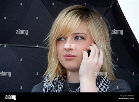 18 Jährige Blondine Hält Regenschirm Suchen Wütend Gespräch Auf Dem Handy Hören Stockfotografie