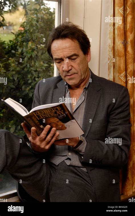 actor robert lindsay reading by a window he has a purpose built library in his home in denham