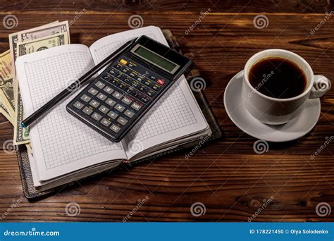 Cup Of Coffee And Notepad With Dollars Pencil And Calculator On Wooden