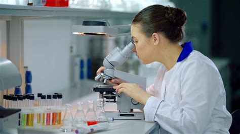 Female scientist with microscope in lab. Woman scientist doing ...