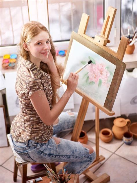 Artist Painting On Easel In Studio Girl Paints With Brush Stock Photo