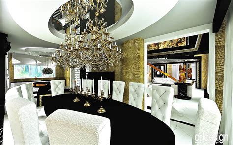 The Dining Room Is Decorated In Black And White With Chandelier Hanging