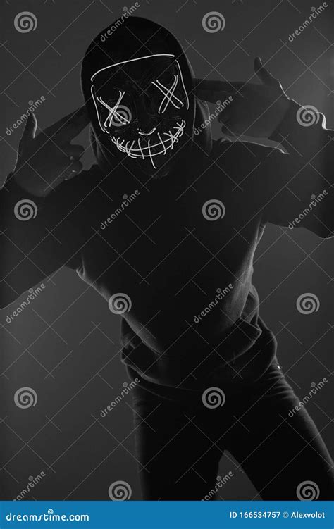 Anonymous Man In Black Hoodie Hiding His Face Behind A Neon Mask Stock Image Image Of