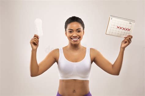 Happy Young Black Woman Demonstrates Periods Calendar And Sanitary
