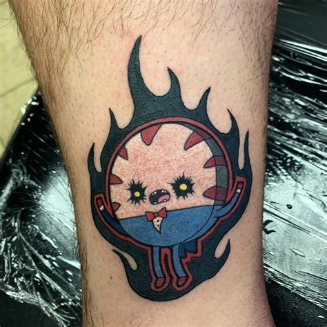 A Tattoo On The Leg Of A Man With An Evil Face And Flames Around It