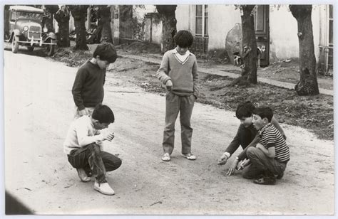 Niños jugando con un tapón de la puerta. BNU-CD: Niños jugando con bolitas en plena calle de La Paz