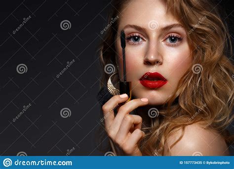 Beautiful Girl With Red Lips And Classic Makeup And Curls With Mascara