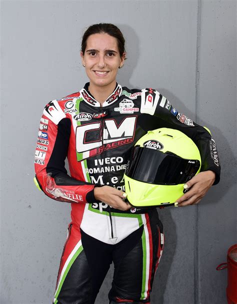 A Woman Is Holding A Helmet And Posing For The Camera