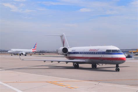 An American Eagle Crj 200 Taxiing At Lax With A New Embraer 175