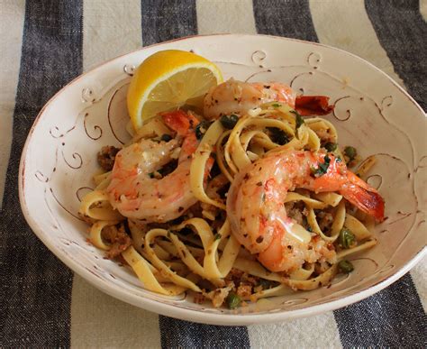 Baked shrimp dishes, vermicelli and sanitary masks are on a wooden table. delicious looking linguine dish with capers, garlic ...