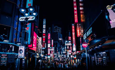 A City Street Filled With Lots Of Neon Signs And Tall Buildings In The