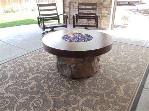 Base for fire pit on grass. Round metal top with a field stone base. 12" stainless ...