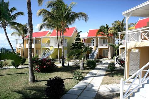 The Resort Has Many Colorful Buildings And Palm Trees In Front Of It