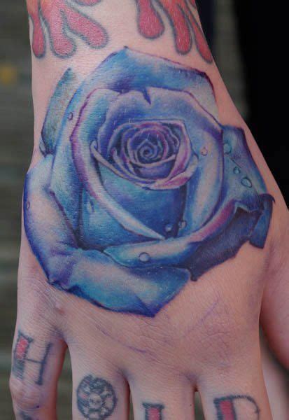Awesome realistic thorny rose tattoo for men hand. Electric blue and realistic rose tattoo done on a hand ...