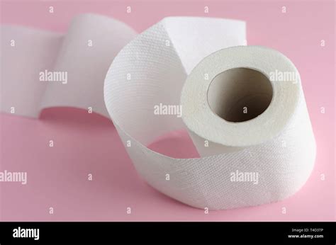 Single White Toilet Paper Roll On Pastel Pink Background Space For