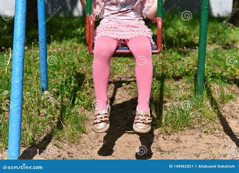 Ноги девушки в розовых колготках на качании Стоковое Изображение изображение насчитывающей
